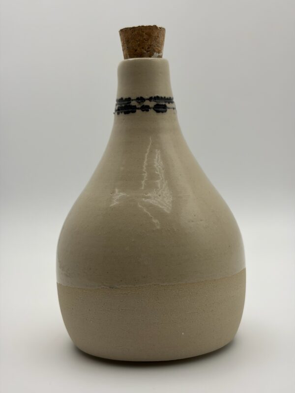Bouteille en grès blanc lisse, émaillé séduit par ses formes douces et généreuses, son émail brillant, transparent et son délicat décor graphique réalisé à la main autour du col. 2 Réserve sphère - Entre les Lignes - Collection ENCRE